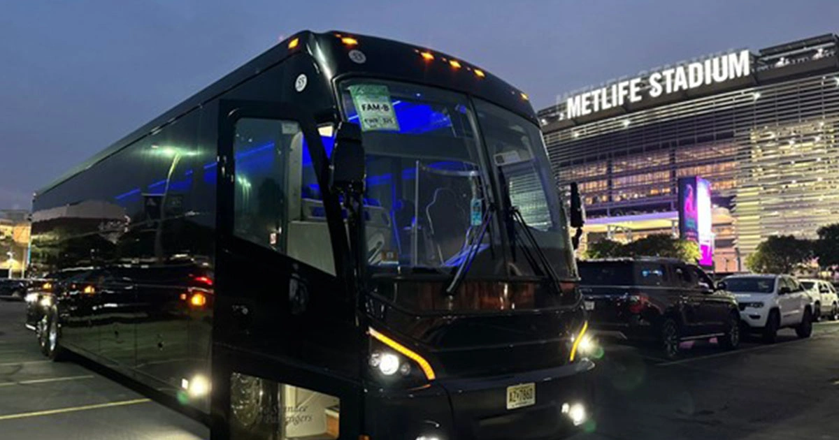Eagles Charters Motorcoach outside MetLife Stadium in the evening.